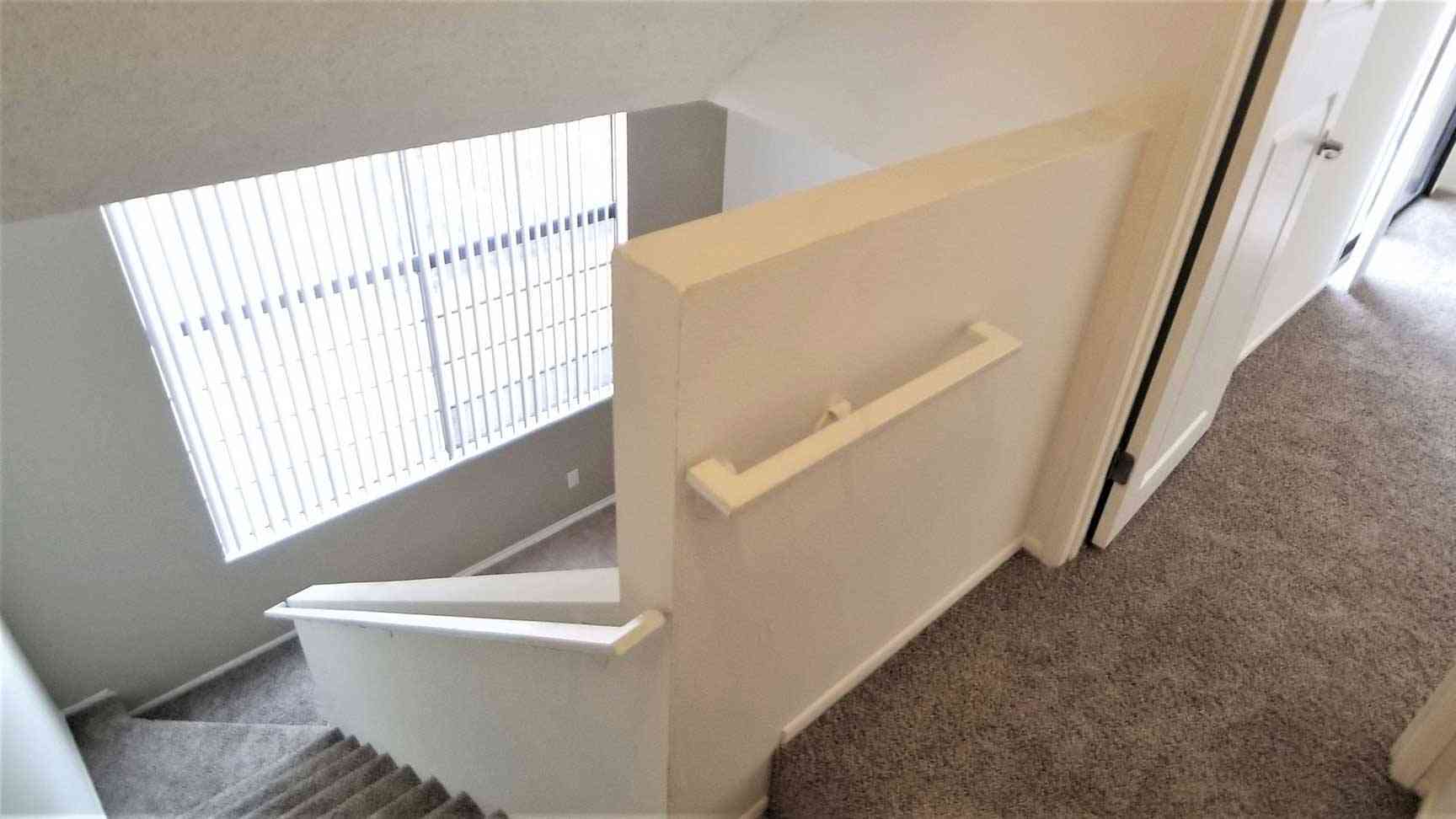 interior staircase leading to carpeted second floor