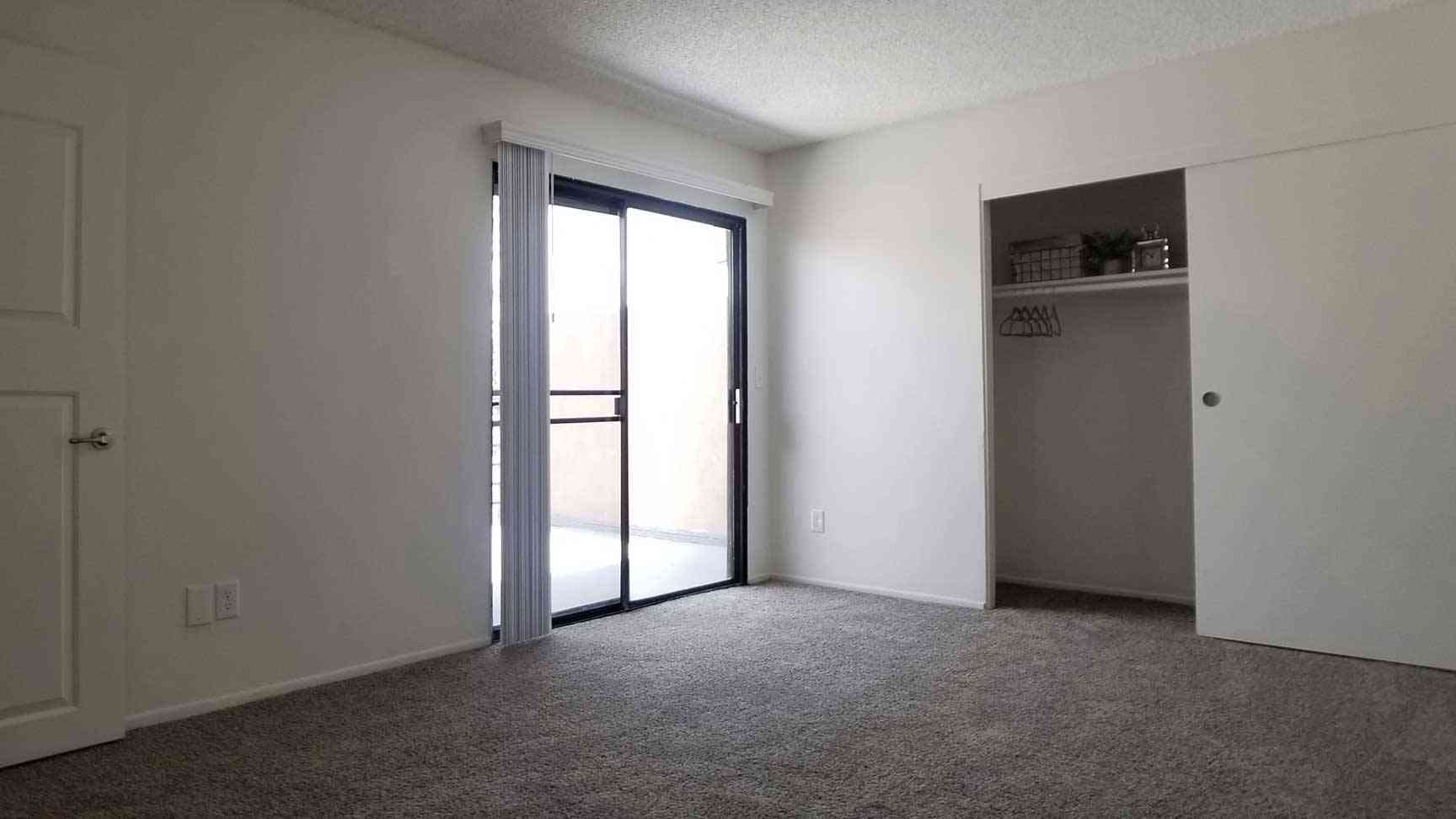 carpeted bedroom with sliding glass patio door