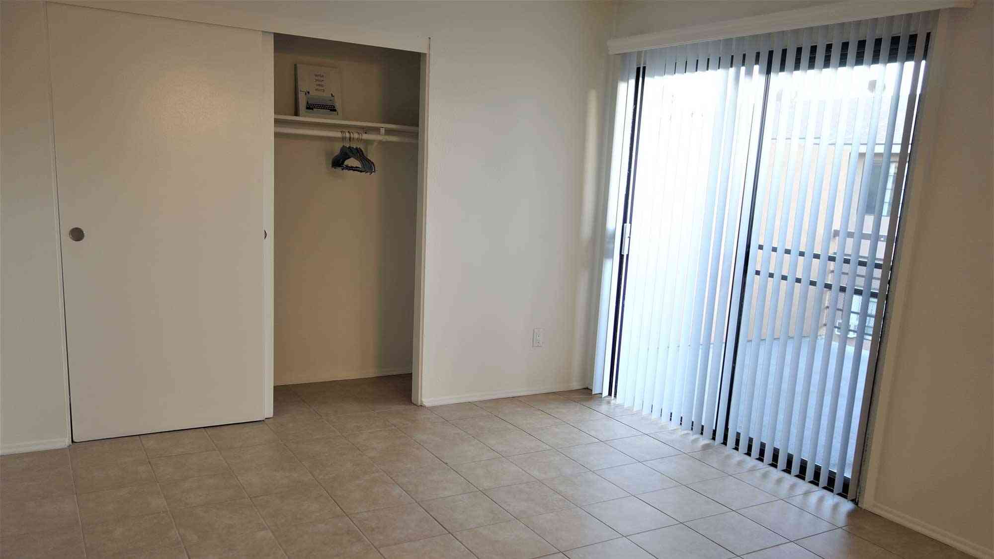 spacious room with tile flooring and vertical blinds